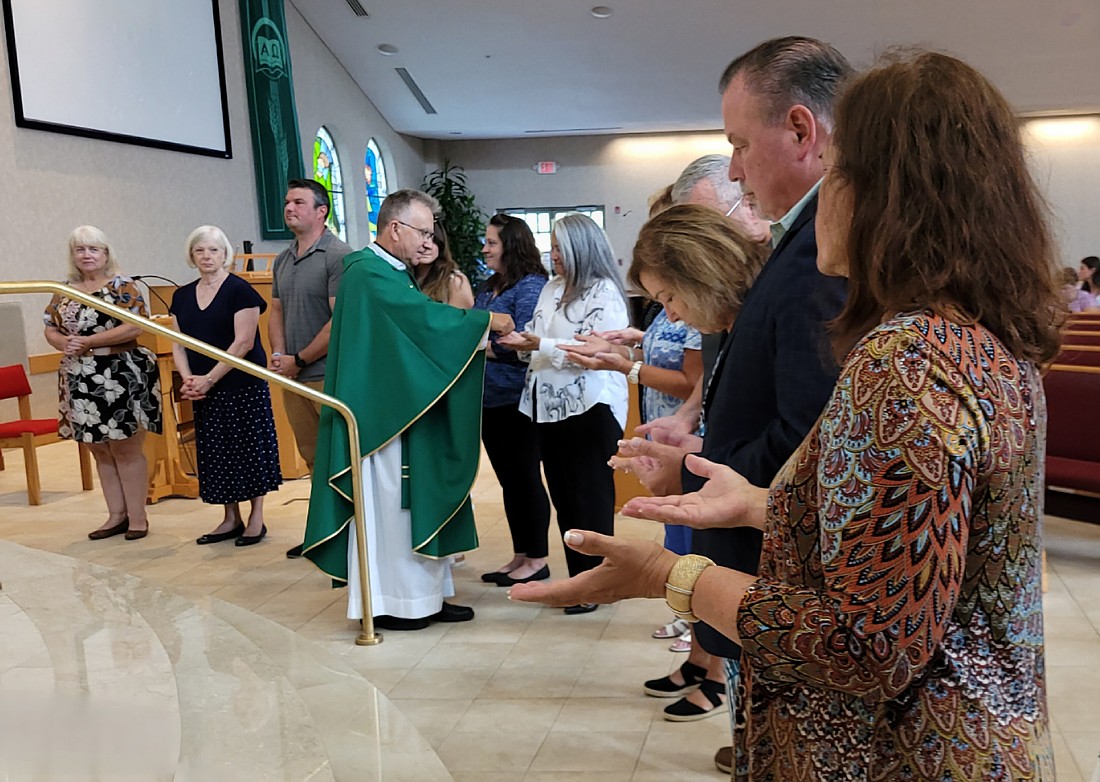 Father Richard Basznianin, pastor of St. Pius X Parish, Forked River, blesses the hands of catechists on Catechetical Sunday, Sept. 15. Hundreds of women and men from around the Diocese were recognized during special commissioning ceremonies that day. Maria Shuflat photo