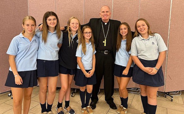 Bishop O'Connell poses for a photo with a group of students during the PTA meeting. Staff photo