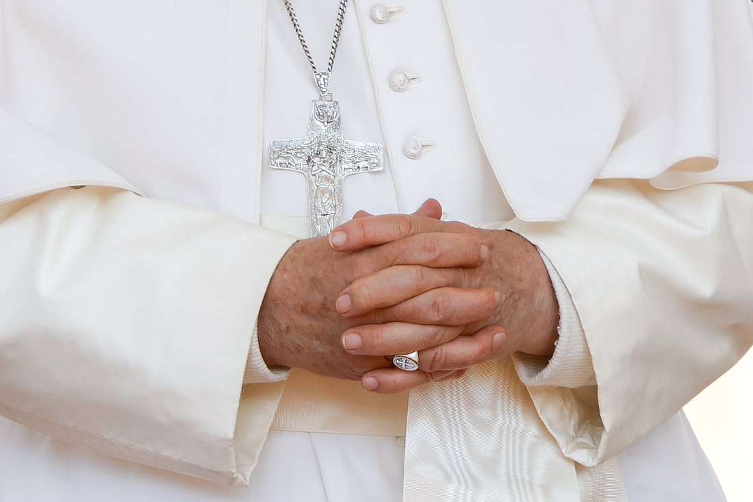 Pope Francis prays with his hands clasped in front of his pectoral cross during his weekly general audience in St. Peter's Square at the Vatican May 15, 2024. (CNS photo/Lola Gomez)