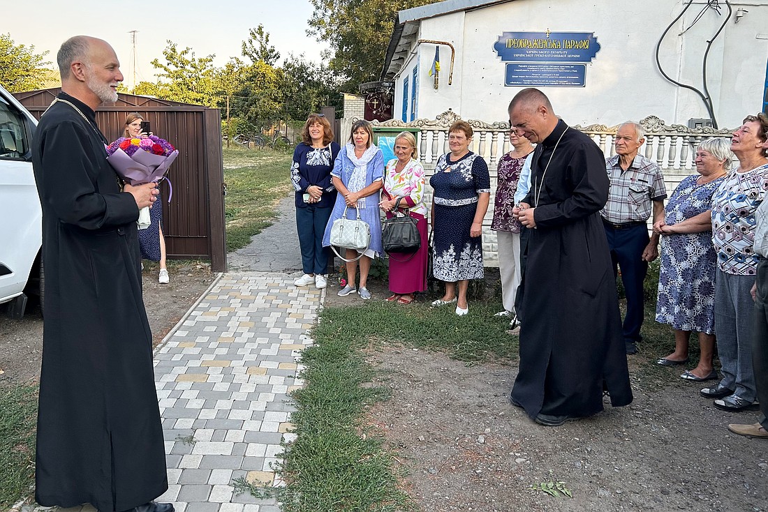 Metropolitan Archbishop Borys A. Gudziak of the Ukrainian Catholic Archeparchy of Philadelphia is greeted by Father Vyacheslav Trysh, pastor, and parishioners of the Ukrainian Catholic Transfiguration of the Lord Parish in Lozova, Ukraine, Sept. 7, 2024. (OSV News photo/Gina Christian)