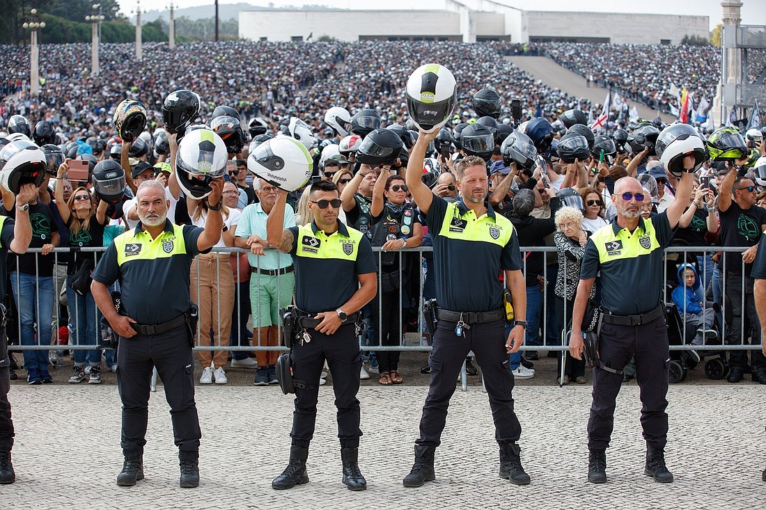 Police officers raise their helmets as 180,000 motorcyclists attend a pilgrimage at the Sanctuary of Our Lady of Fátima Sept. 22, 2024. After a blessing, Bishop Rui Manuel Sousa Valério, patriarch of Lisbon, told them that they can carry out "a true prophetic mission" and blessed their helmets during their ninth pilgrimage to the famous Portuguese Marian shrine. (OSV News photo/courtesy Sanctuary of Our Lady of Fátima)