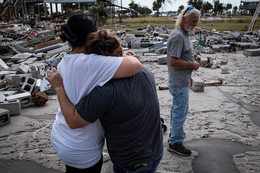 Women embrace Sept. 28, 2024, as Dave (no last name provided) looks at the remains of his destroyed house in Horseshoe Beach, Fla., following Hurricane Helene. (OSV News photo/Marco Bello, Reuters)