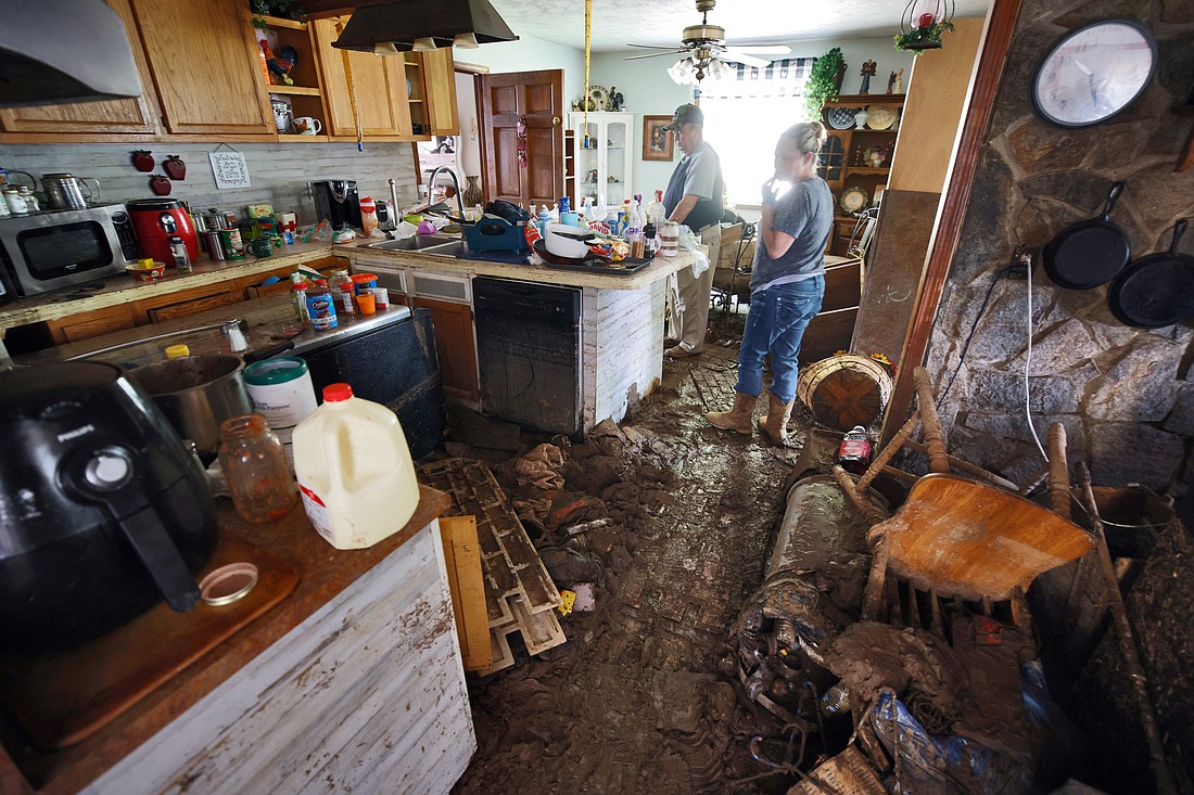 Charles English and his daughter Sabra, walk through his badly flooded home in Barnardsville, N.C., Oct. 2, 2024, as they retrieve belongings after the remnants of Hurricane Helene hit the town. The storm made landfall the night of Sept. 26 in Florida's Big Bend region as a Category 4 hurricane and was downgraded to a tropical storm the next morning. (OSV News photo/Jonathan Drake, Reuters)