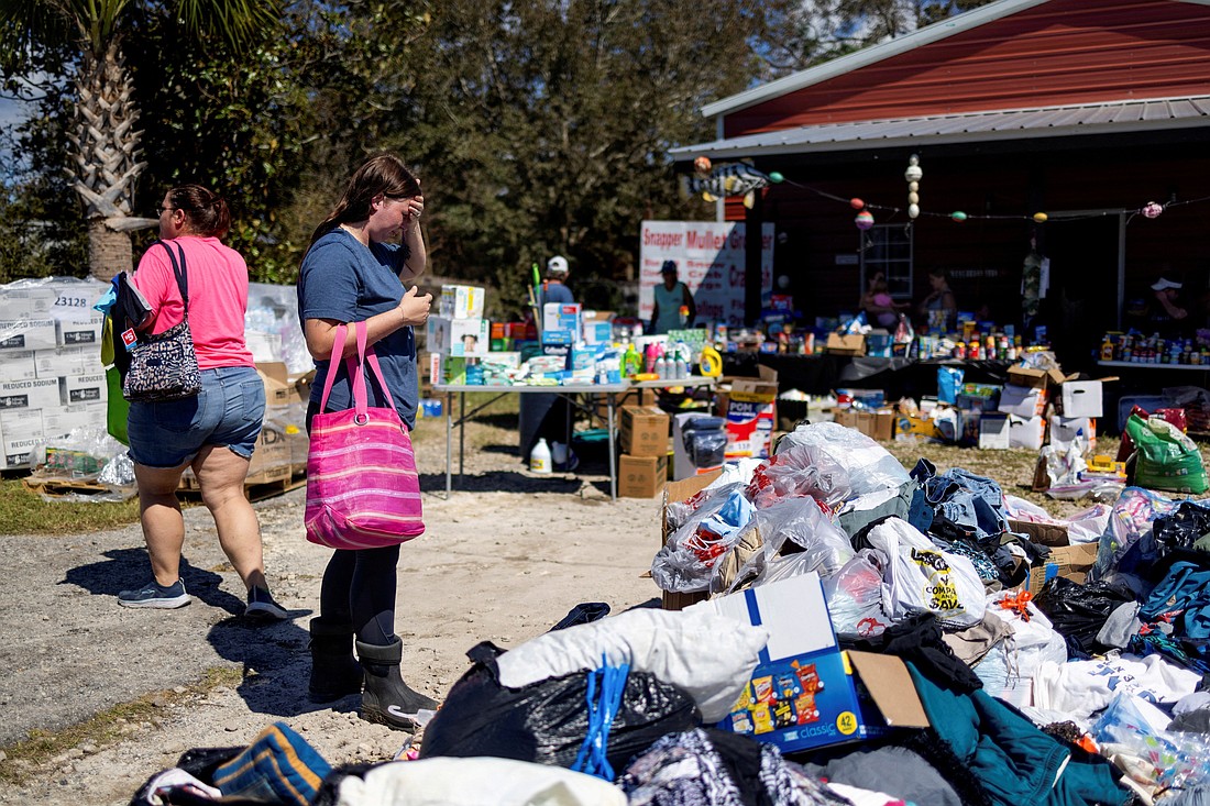 Maddie Hackney, who lost everything to the hurricane, pauses while looking for clothing Sept. 29, 2024, at a donation center in Steinhatchee, Fla.,  organized by Janalea and Garrett England at their business Steinhatchee Fish Co. in the wake of Hurricane Helene. (OSV News photo/Kathleen Flynn, Reuters)