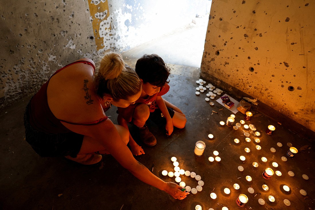 A boy and his mother light memorial candles inside a bomb shelter near Kibbutz Mefalsim in southern Israel Oct.  7, 2024, on the first anniversary of the deadly attack by Hamas on Israel.  (OSV News photo/Amir Cohen, Reuters)