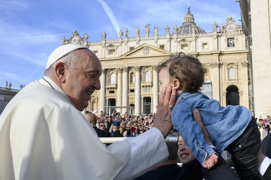 Pope Francis greets a child as he rides in the popemobile before his general audience in St. Peter's Square at the Vatican Oct. 9, 2024. (CNS photo/Vatican Media)