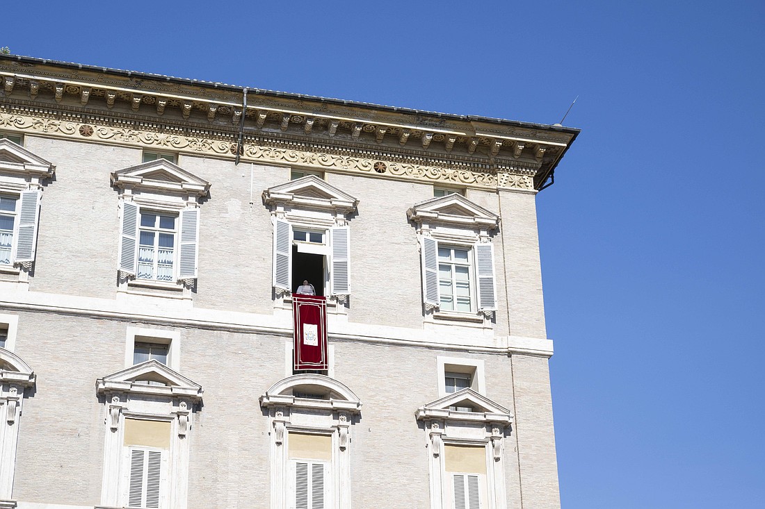 Pope Francis stands in the window of his studio in the Apostolic Palace at the Vatican as thousands of people gather below him in St. Peter's Square for the recitation of the Angelus prayer Oct. 13, 2024. (CNS photo/Vatican Media)