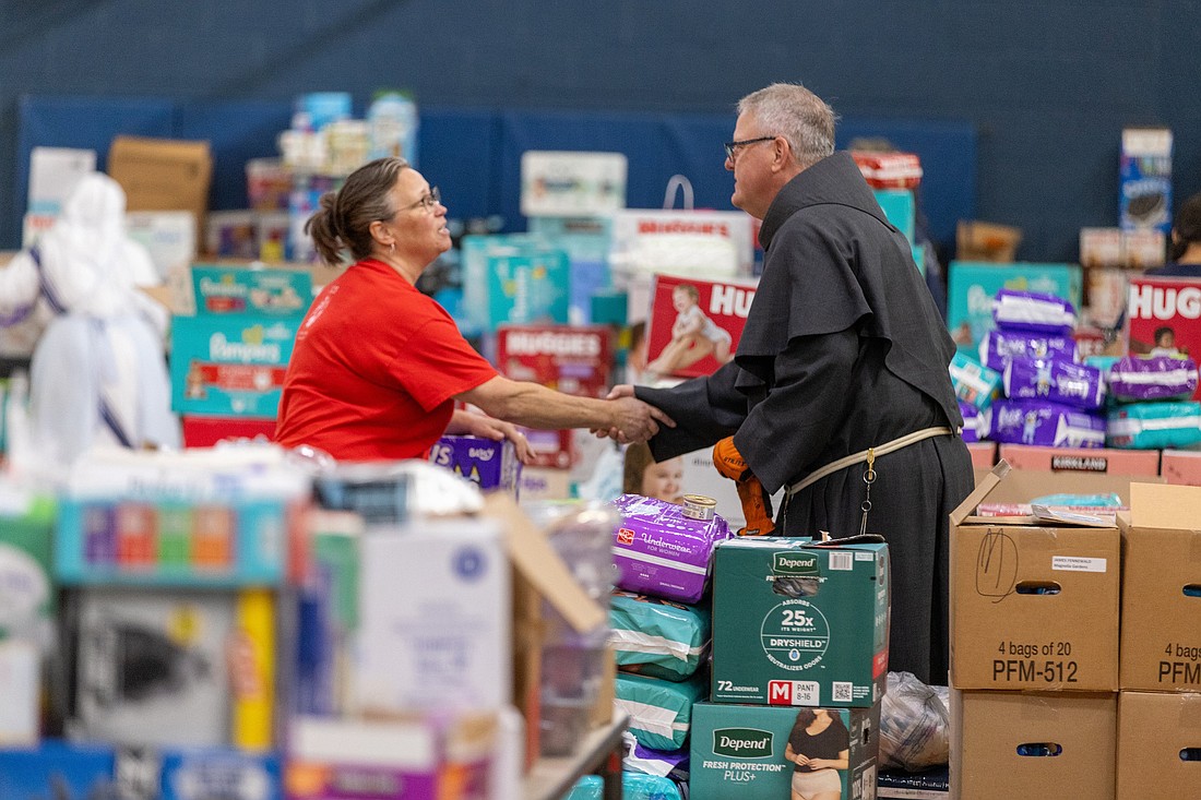 Charlotte Bishop Michael Martin talks with a volunteer Oct. 4, 2024, at Immaculata Catholic School in Hendersonville, N.C. The school, although suffering flood damage and power loss, has become a major aid distribution site for the area in the aftermath of Tropical Storm Helene. Martin, who was ordained bishop of Charlotte only four months ago, traveled the region to survey the damage, bring aid supplies and speak to aid volunteers, and offer spiritual comfort. Nearly half of the parishes in the Diocese of Charlotte are located within the federal emergency disaster zone of western North Carolina. (OSV News photo/Gabriel Swinney for the Catholic News Herald)