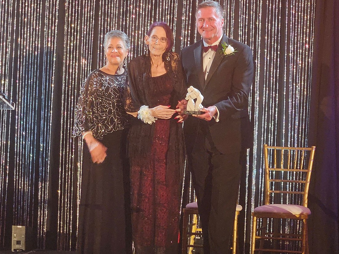 Jean Boyle, shown centered is presented with the Client Achievement Award during Catholic Charities Guardian Angel Dinner Dance Sept. 25. With Boyle are Marlene Lao-Collins, Catholic Charities executive director, left, and Michael W. Herbert, chair of the agency's board of trustees. Mary Stadnyk photo