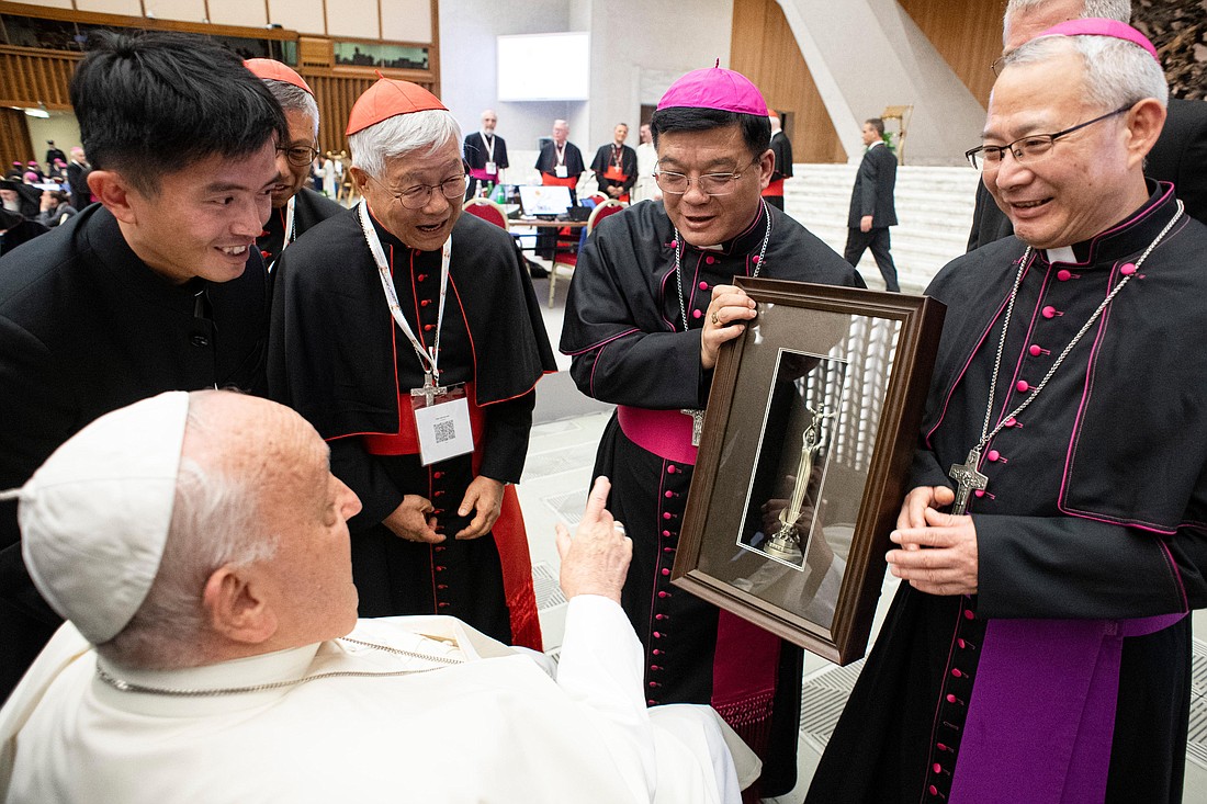 Bishops Joseph Yang Yongqiang of Hangzhou, center, and Vincent Zhan Silu of Funing-Mindong, left, the two members of the Synod of Bishops from mainland China give Pope Francis a gift during a break in the meeting of the Synod of Bishops in the Paul VI Audience Hall at the Vatican Oct. 2, 2024. (CNS photo/Vatican Media)..