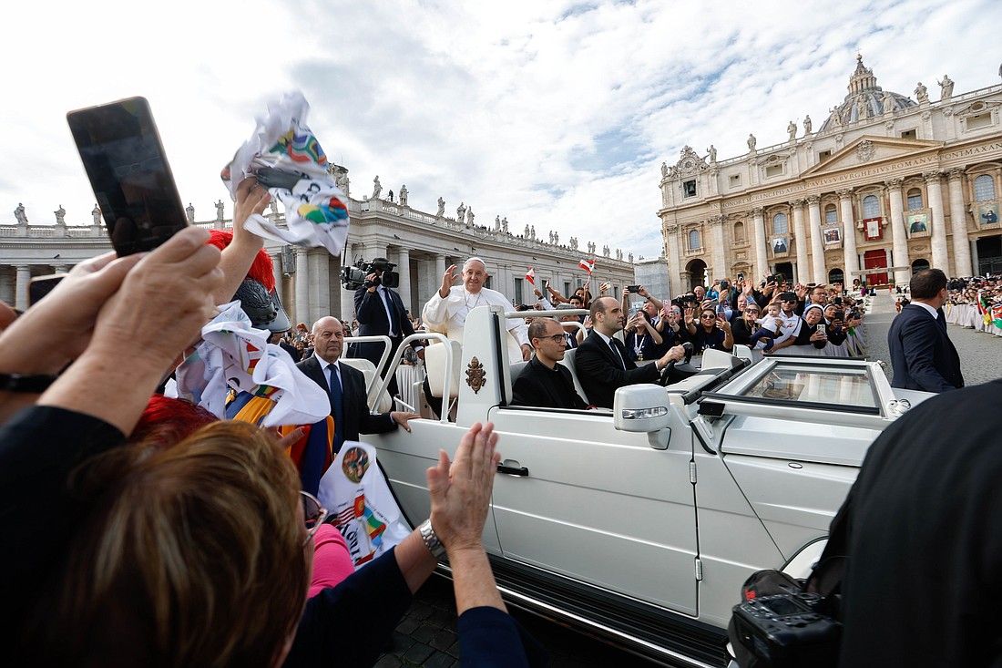 Pope Francis greets visitors as he rides in the popemobile through St. Peter's Square after presiding over the canonization Mass for 14 new saints on World Mission Sunday at the Vatican Oct. 20, 2024. (CNS photo/Lola Gomez)