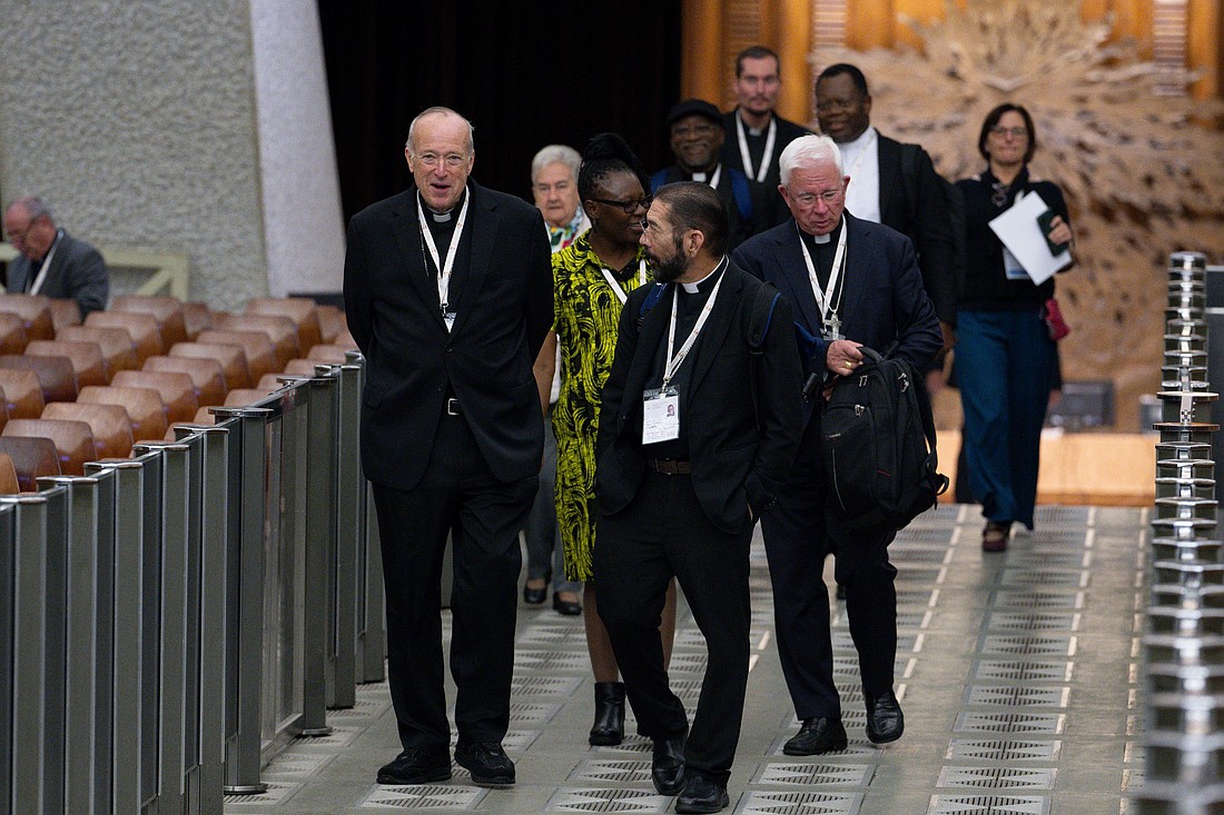 Cardinal Robert W. McElroy of San Diego, left, and Bishop Daniel E. Flores of Brownsville, Texas, arrive for a working session of the Synod of Bishops in the Paul VI Audience Hall at the Vatican Oct. 11, 2024. (CNS photo/Vatican Media)