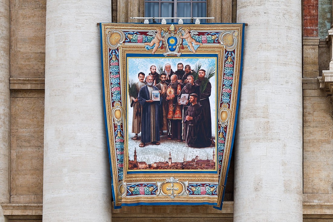 A banner depicting the "Martyrs of Damascus" -- eight Franciscan friars and three Maronite laymen martyred in Syria in 1860 -- hangs from the front of St. Peter’s Basilica at the Vatican Oct. 16, 2024, ahead of their Oct. 20 canonization. (CNS photo/Lola Gomez)