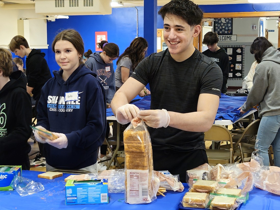 Young people from St. Mary of the Lakes Parish and School, Medford, prepare bag lunches as they participate in a Martin Luther King Day of Service this past January. Mary Stadnyk photo