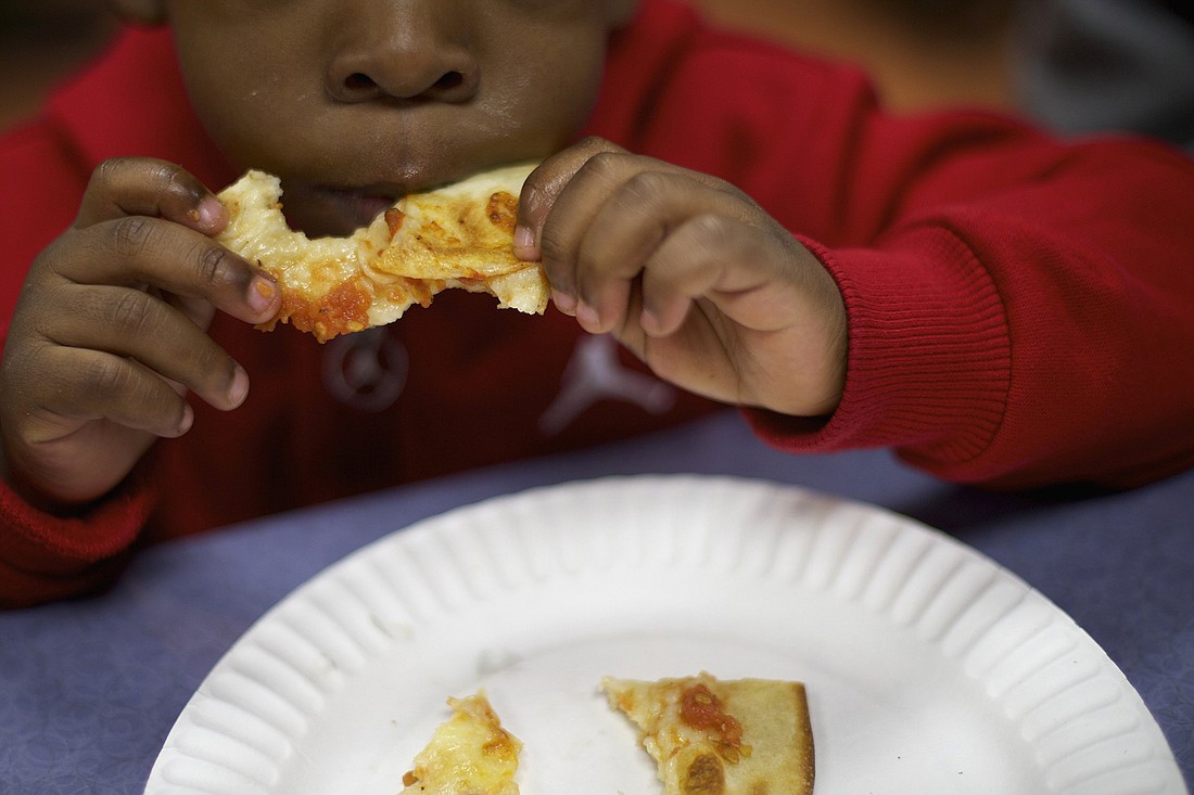 A child is seen in a file photo enjoying free pizza for homeless families at a restaurant in Philadelphia. OSV News photo/Mark Makela, Reuters