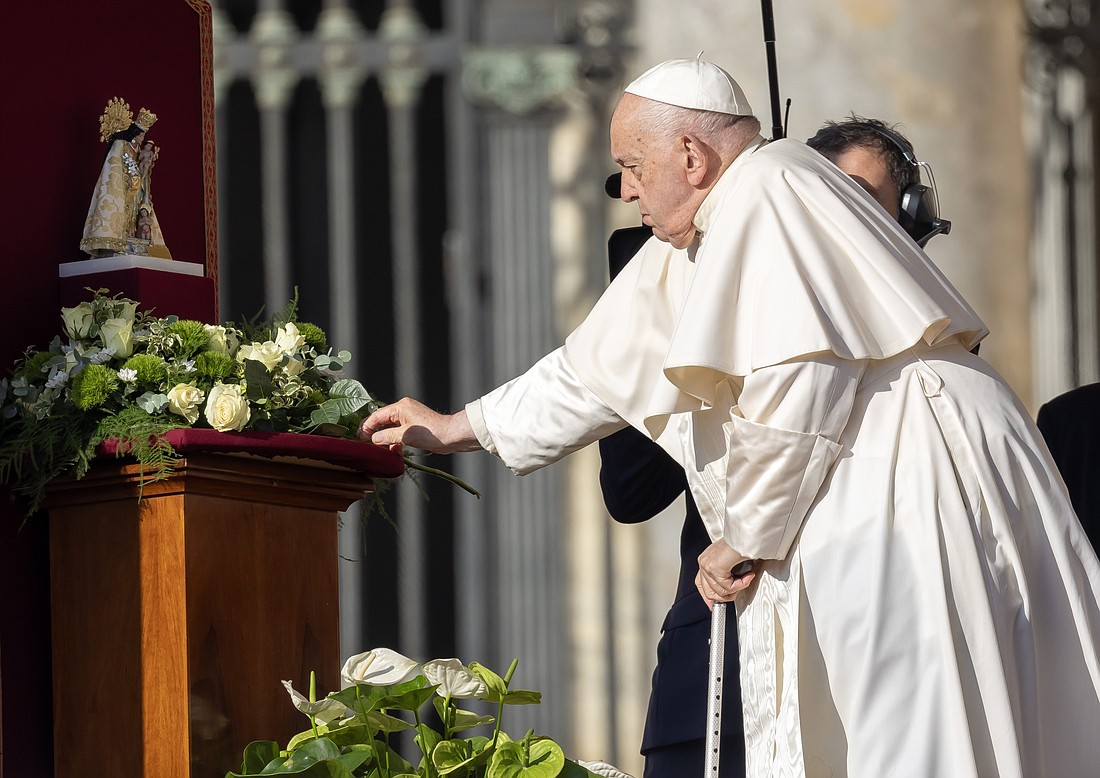 Pope Francis places a rose before a statue of Our Lady of the Forsaken, the patroness of Valencia, Spain, before leading people attending his general audience in St. Peter's Square at the Vatican Nov. 6, 2024, in prayers for the victims of flooding in Spain. (CNS photo/Pablo Esparza)