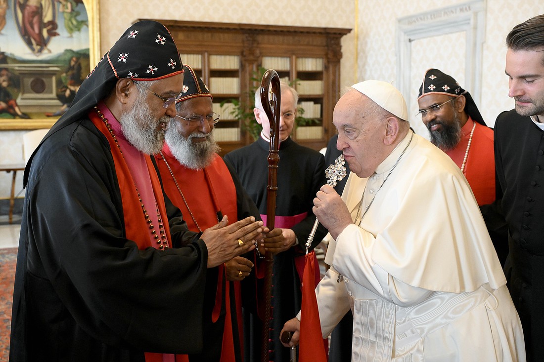 Pope Francis kisses the cross of a bishop from the India-based Malankara Mar Thoma Syrian Church after a meeting in the library of the Apostolic Palace at the Vatican Nov. 11, 2024. (CNS photo/Vatican Media)
