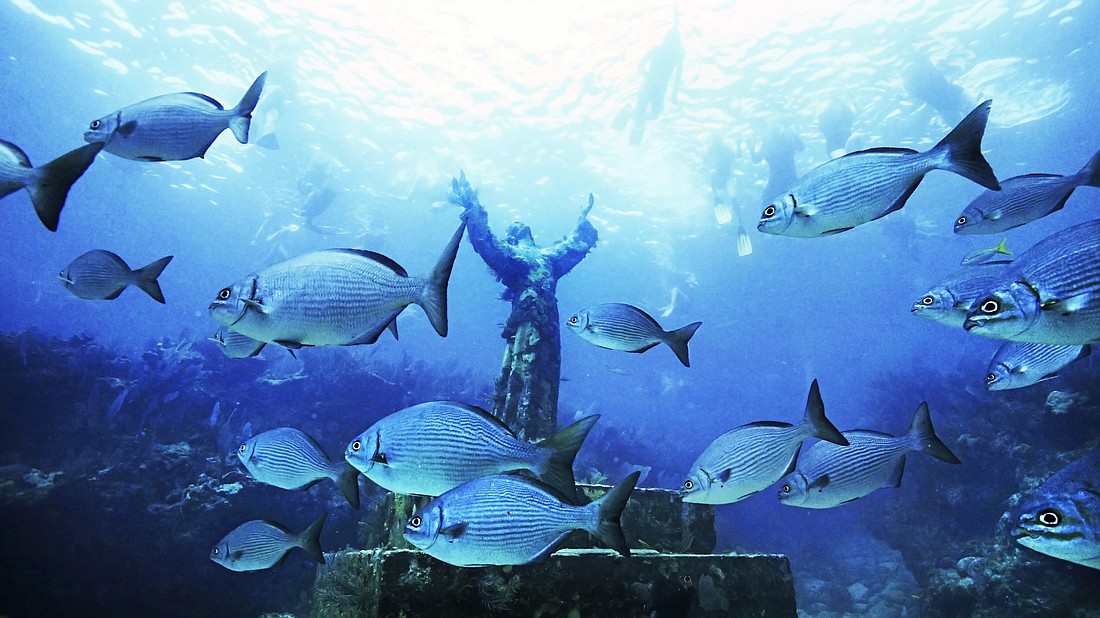 A replica of Christ of the Abyss statue is pictured surrounded by fish in the Florida's Key Largo John Pennekamp State Park. The mold was made from the original statue off the Italian Riviera, where pioneer Italian diver Dario Gonzatti lost his life scuba diving in 1947. At the Italian site there now stands a bronze Christ, created by Italian sculptor Guido Galletti. (CNS photo/courtesy VISIT FLORIDA).