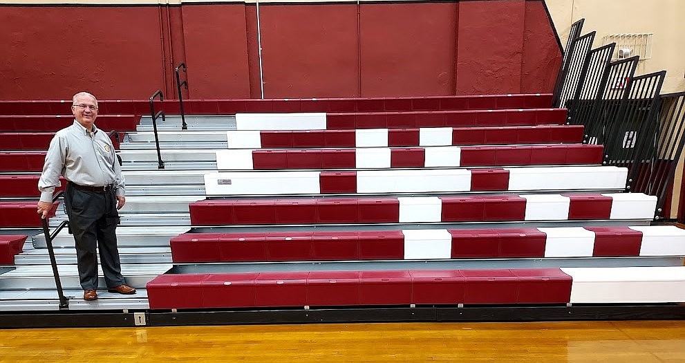 CYO Mercer executive director Tom Mladenetz proudly stands next to the new bleachers for which he and many others worked to gain funding. Rich Fisher photo