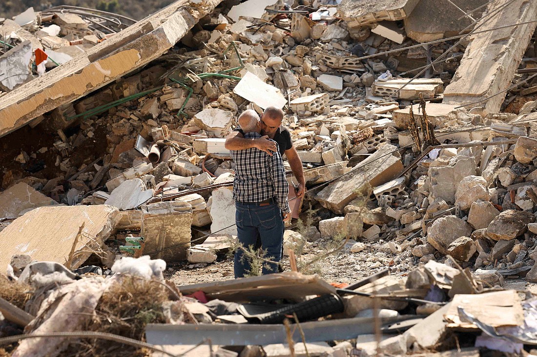 People hug as they stand on rubble of damaged buildings in Joun village in Lebanon's Chouf district Nov. 13, 2024, in the aftermath of Israeli strikes amid the ongoing hostilities between Hezbollah and Israeli forces. (OSV News photo/Aziz Taher, Reuters)