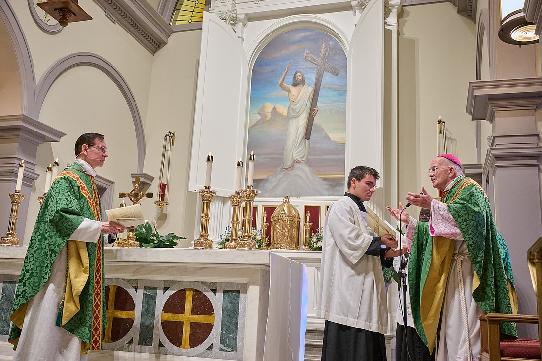 Bishop David M. O'Connell, C.M., congratulates Father Michael Lankford-Stokes following the ceremony during which he was installed as pastor of Holy Cross Parish, Rumson. Mike Ehrmann photo