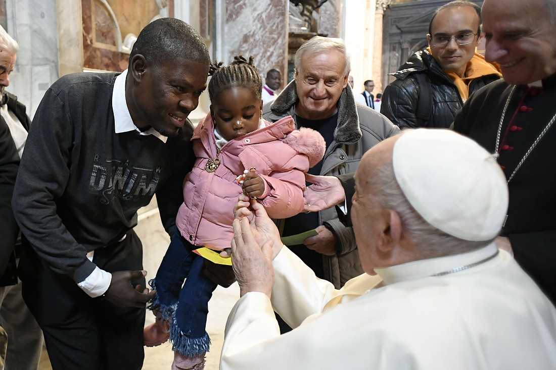 Pope Francis offers candy to a child after celebrating Mass for the World Day of the Poor in St. Peter's Basilica Nov. 17, 2024. (CNS photo/Vatican Media)