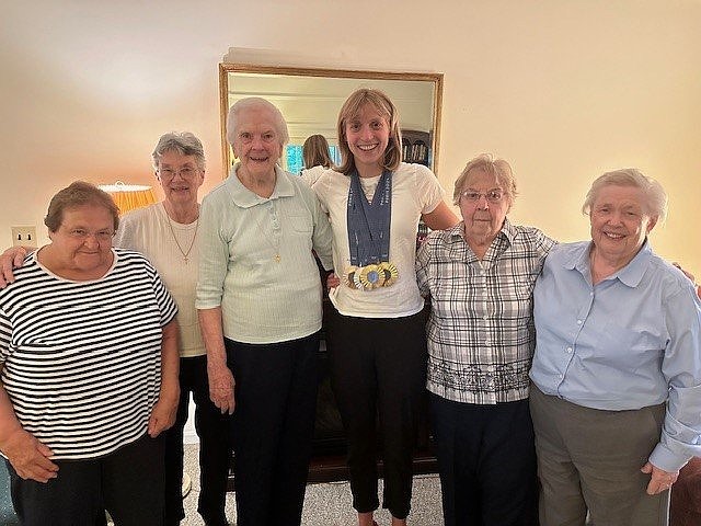 After winning four medals at the 2024 Summer Olympic Games in Paris, champion swimmer Katie Ledecky, center, poses with Immaculate Heart of Mary sisters at their convent at the Church of the Little Flower in Bethesda, Md. Ledecky and her family are parishioners there, and she graduated from Little Flower School in 2011. From left to right are Sister Madonna Lenikus, Sister Ann Parker, Sister Rosemaron Rynn, Sister Ritamary Mayan and Sister Jane Mary Duke. (OSV News Courtesy photo) Editors: best quality available.