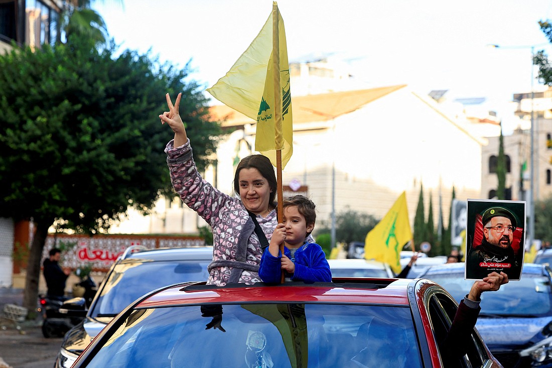 A woman accompanied by a child holding a Hezbollah flag gives a victory sign from a car at the entrance of Beirut's southern suburbs Nov. 27, 2024, after a ceasefire between Israel and Hezbollah took effect. A ceasefire between Israel and the Lebanese militant group Hezbollah appeared to be holding as residents returned toward southern Lebanon, despite warnings from the Israeli and Lebanese military that they stay away from certain areas. (OSV News photo/Thaier Al-Sudani, Reuters)