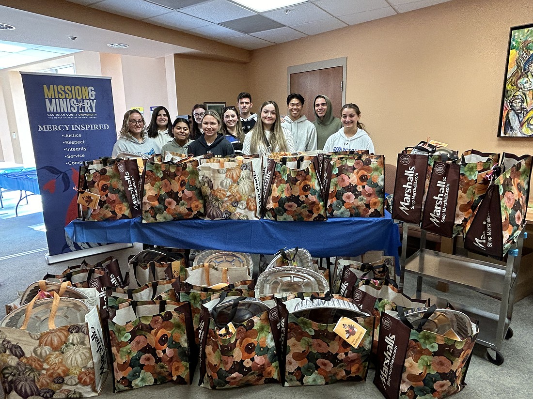 Georgian Court University students stand with the grocery bag "baskets" they filled for distribution to local families by Interfaith Family Services (Toms River) and Providence House-Ocean County (Whiting). Courtesy photo