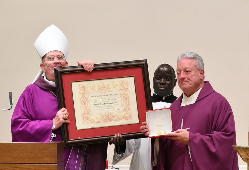 Father Jeffrey Lee, right, is presented with “The Pro Ecclesia et Pontifice Medal” by Bishop O'Connell on Nov. 30. Mike Ehrmann photo