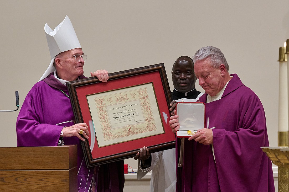 Father Jeffrey Lee, right, is presented with “The Pro Ecclesia et Pontifice Medal” by Bishop O'Connell on Nov. 30. Mike Ehrmann photo