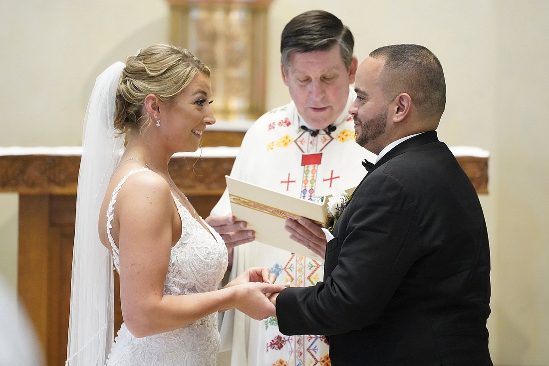 Christina MacDougall places a wedding band on Julio Prendergast's finger as Msgr. Francis J. Schneider officiates their wedding Mass Aug. 20, 2021, at St. John the Baptist Church in Wading River, N.Y. (OSV News photo/Gregory A. Shemitz)