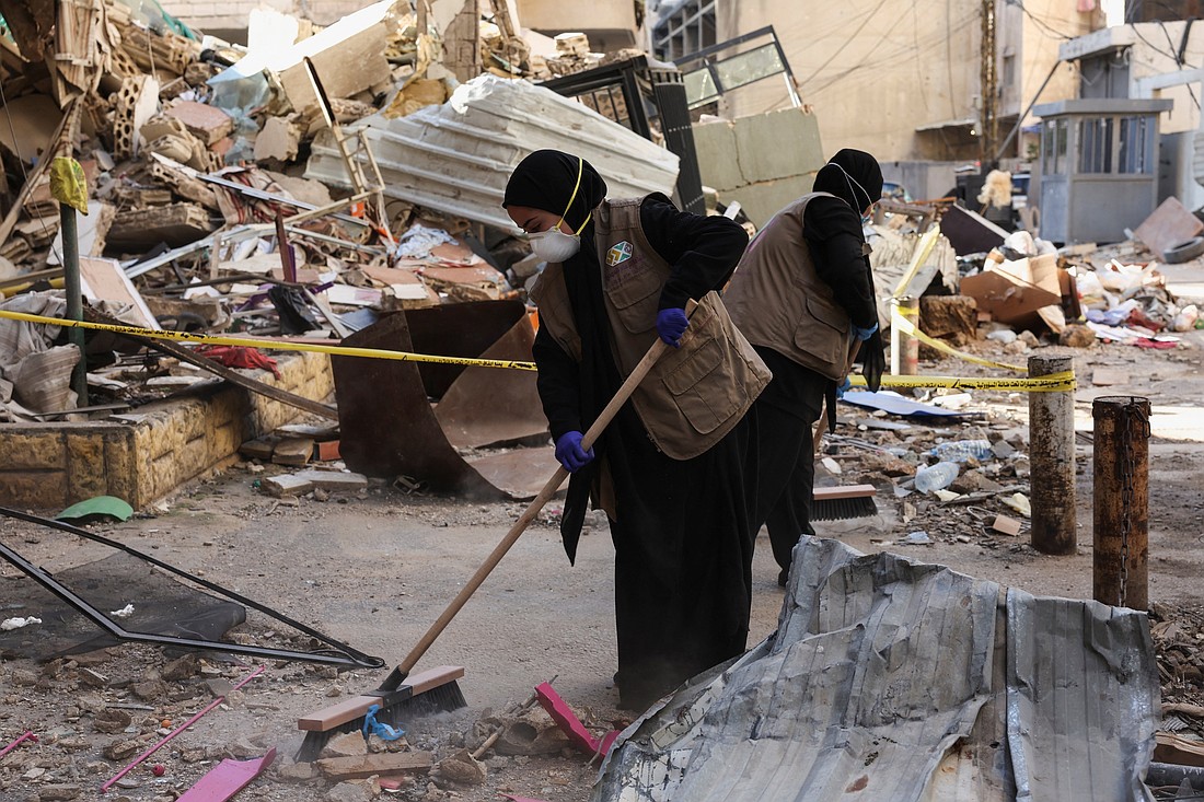 Members of Imam al-Mahdi scouts clean rubble and debris from damaged buildings in Beirut's southern suburbs Dec. 2, 2024, after a ceasefire between Israel and Hezbollah took effect the morning of Nov. 27. (OSV News photo/Mohamed Azakir, Reuters)