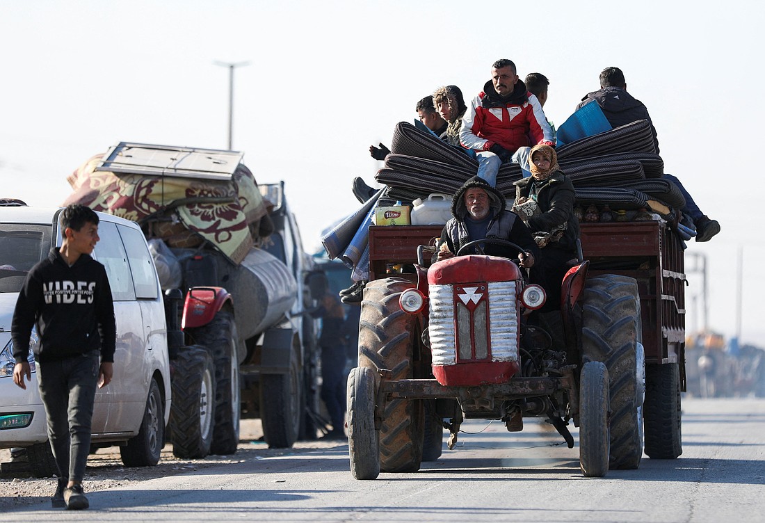 Displaced Syrians who fled from the Aleppo countryside ride on a vehicle with their belongings in Tabqa, Syria, Dec. 3, 2024. (OSV News photo/Orhan Qereman, Reuters)