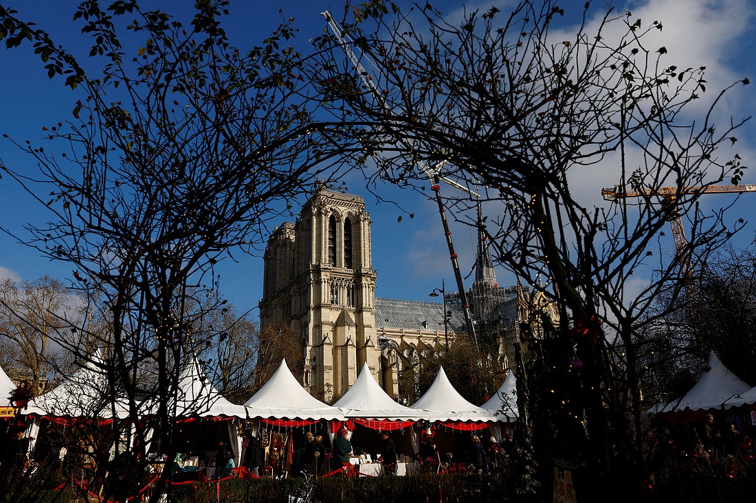 A Christmas market is seen along the banks of the Seine River  in Paris Dec. 4, 2024, near Notre Dame Cathedral, which was ravaged by a fire in 2019. Restoration work continued before the Dec. 7-8 reopening ceremonies. (OSV News photo/Stephanie Lecocq, Reuters)