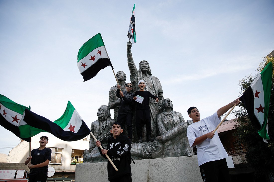 People celebrate next to a sculpture of Sultan Pasha al-Atrash, a Druze warrior who led a revolt against French rule in 1925, after Syrian rebels announced that they had ousted President Bashar Assad, in Majdal Shams, a Druze village in the Israeli-controlled Golan Heights, Dec. 9, 2024. (OSV News photo/Shir Torem, Reuters)