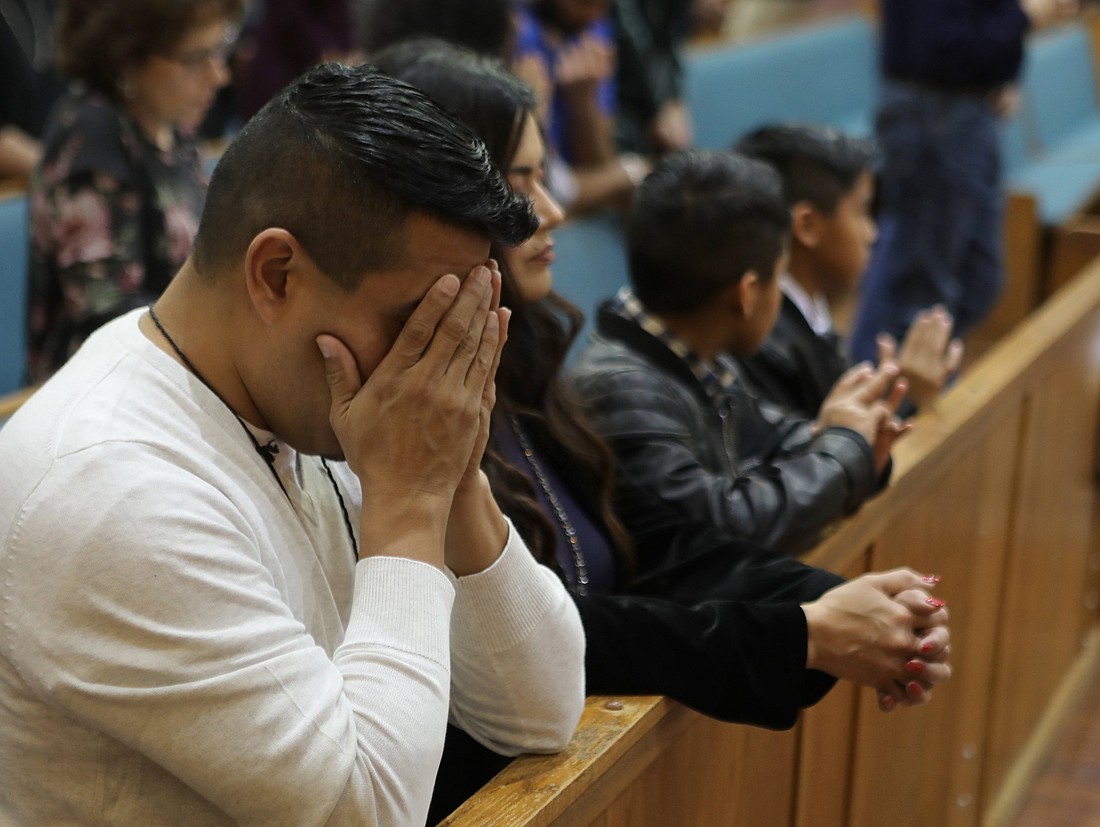 A family prays during a 2019 Christmas Mass at San Jose Catholic Church in Austin, Texas. About one in four Americans are alienated from an immediate family member, according to a 2022 YouGov survey. (OSV News photo/Bob Roller)