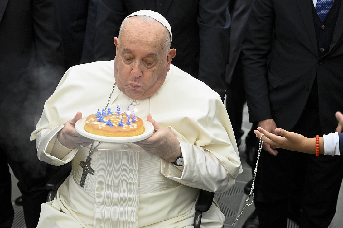 One day after his 88th birthday, Pope Francis blows out the candles on a cake given to him at the end of his weekly general audience Dec. 18, 2024, in the Paul VI Audience Hall at the Vatican. (CNS photo/Vatican Media)