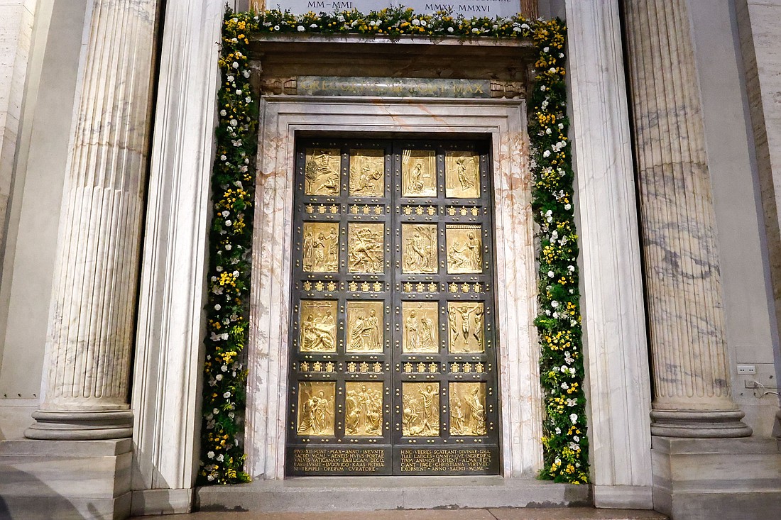 The Holy Door of St. Peter’s Basilica at the Vatican is adorned with flowers in this file photo from May 9, 2024. The Vatican announced Nov. 25 that a webcam will be installed above the door for the Holy Year 2025. (CNS photo/Lola Gomez)