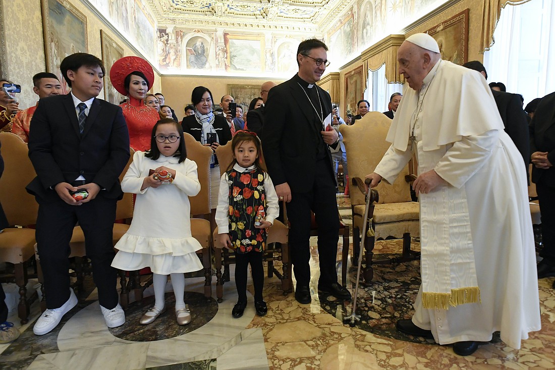 Archbishop Emilio Nappa, president of the Pontifical Mission Societies International, stands to greet Pope Francis during a meeting at the Vatican Dec. 19, 2024, with Vietnamese benefactors who live in the United States. (CNS photo/Vatican Media)