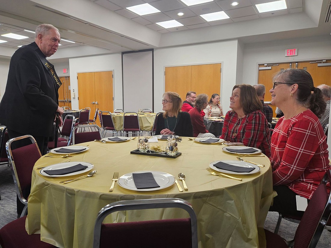 Msgr. Dermond makes the rounds to chat with colleagues during the brunch held in his honor. Staff photos