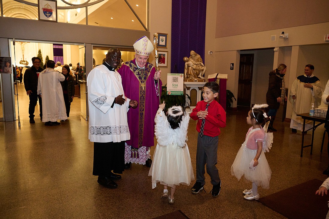 Bishop O'Connell greets parishioners after the Dec. 20 Mass he celebrated for Simbang Gabi in St. Robert Bellarmine Co-Cathedral. Mike Ehrmann photo