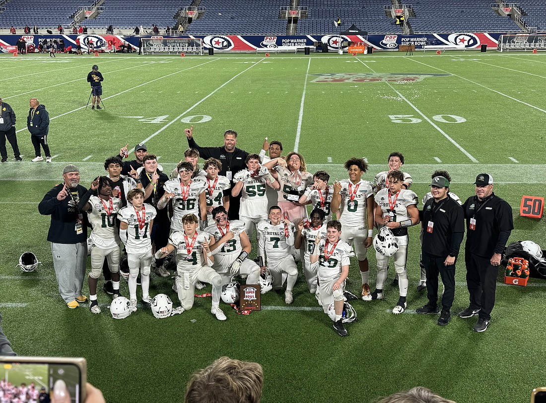 The St. James Royals show off their banners after defeating Coyote Creek, Cal., in the Pop Warner 14U Super Bowl in Orlando. Meredith Barber photo