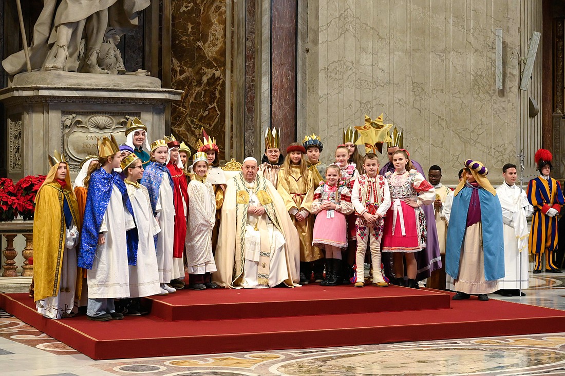 Pope Francis poses for a photo with young people -- dressed as the three kings who vistited Jesus -- during Mass in St. Peter's Basilica at the Vatican Jan. 1, 2025, the feast of Mary, Mother of God, and World Peace Day. (CNS photo/Vatican Media)