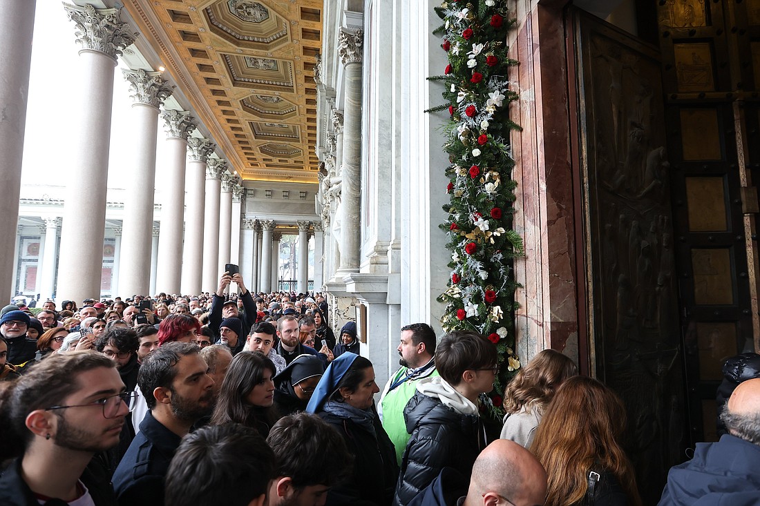 Visitors walk through the Holy Door of the Basilica of St. Paul Outside the Walls in Rome Jan. 5, 2025, after its ceremonial opening by U.S. Cardinal James M. Harvey, archpriest of the Basilica, at the start of the Holy Year 2025. (CNS photo/Lola Gomez)