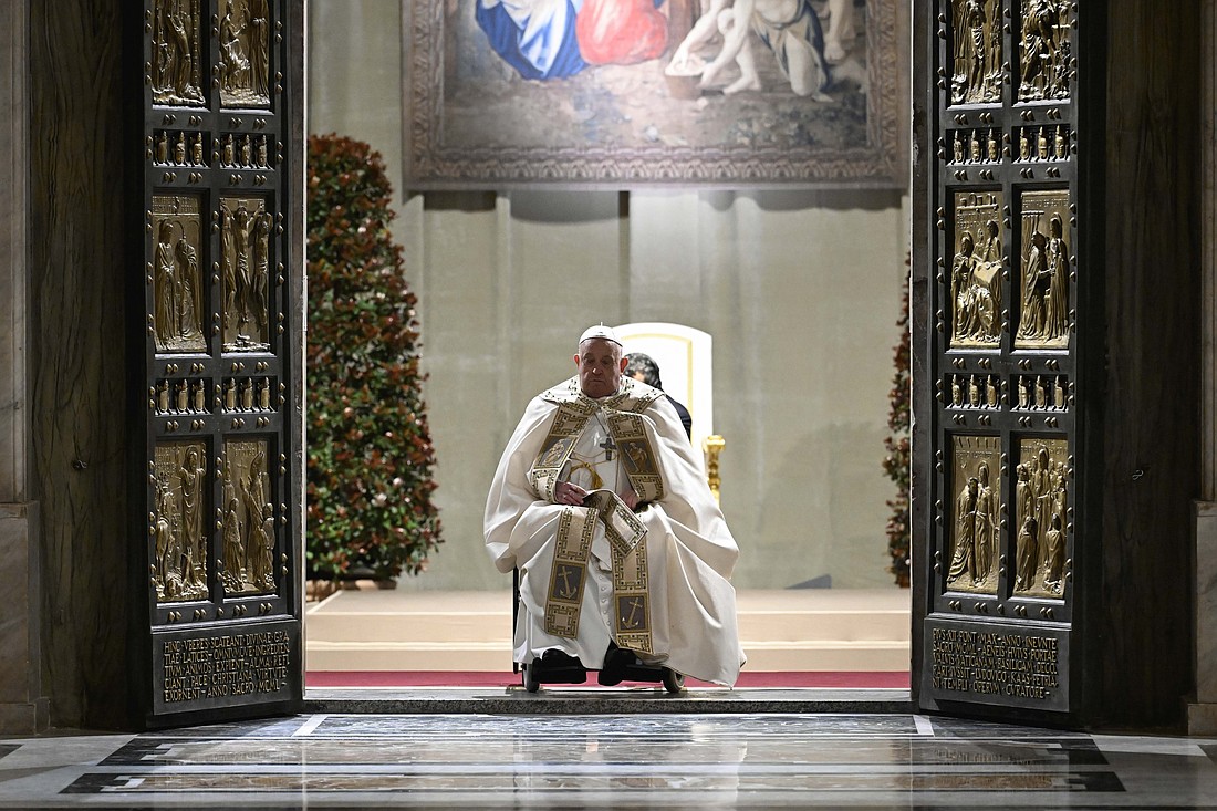 Pope Francis pauses in prayer on the threshold of the Holy Door of St. Peter's Basilica at the Vatican Dec. 24, 2024, after he opened it and inaugurated the Holy Year 2025. (CNS photo/Vatican Media)