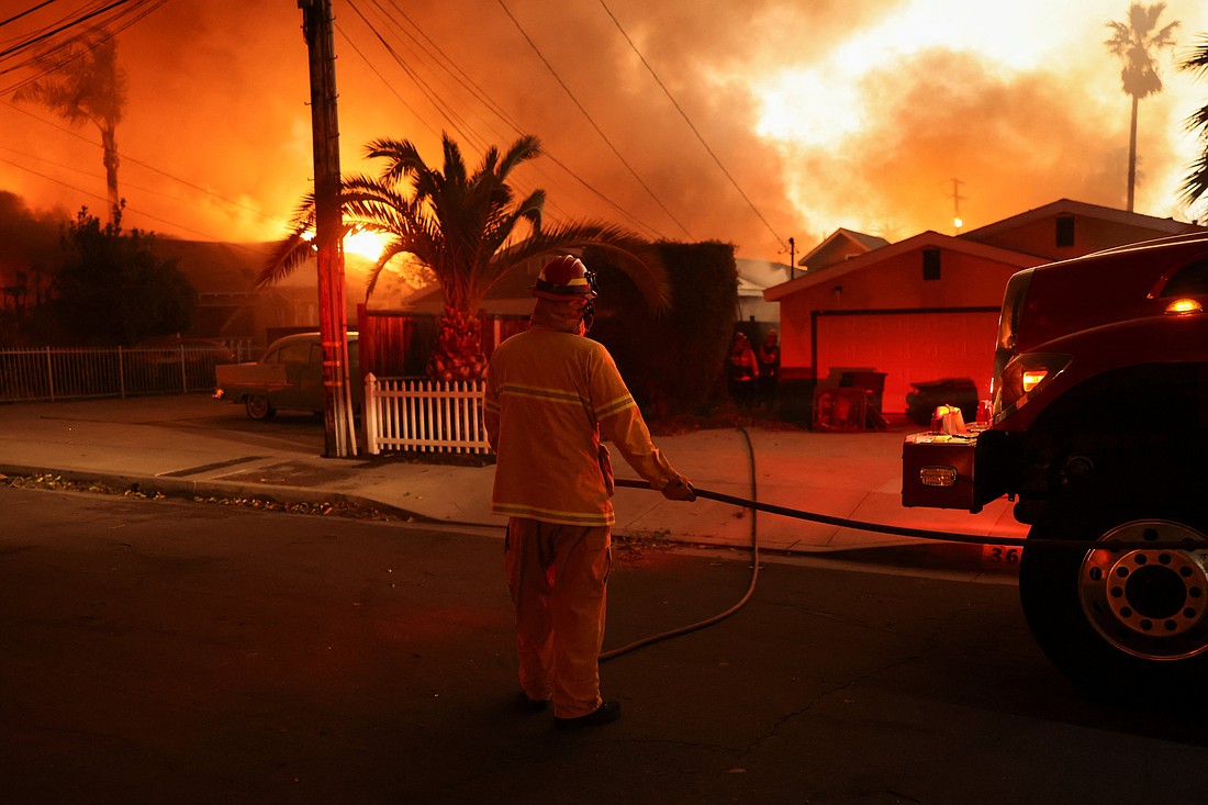 A firefighter works near homes during a weather-driven windstorm in Altadena, Calif., Jan. 8, 2025, that fueled ferocious wildfires. The fires tore across the Los Angeles area with devastating force Jan. 8 after setting off a desperate escape for residents from burning homes through flames, ferocious winds and towering clouds of smoke. (OSV News photo/David Swanson, Reuters)..