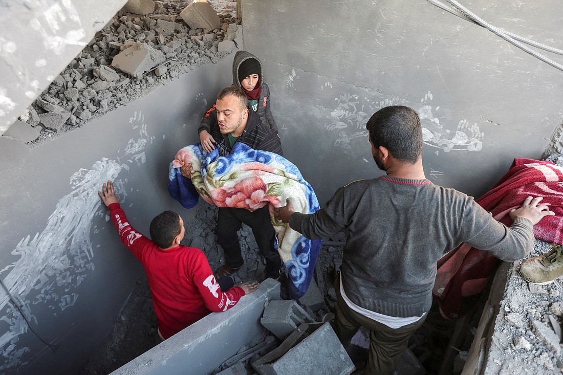 Palestinians carry the dead body of a child Jan. 9, 2025, at the site of an Israeli airstrike on a house in Nuseirat, in the central Gaza Strip. The airstrike came amid the ongoing conflict between Israel and Hamas. (OSV News photo/Ramadan Abed, Reuters)