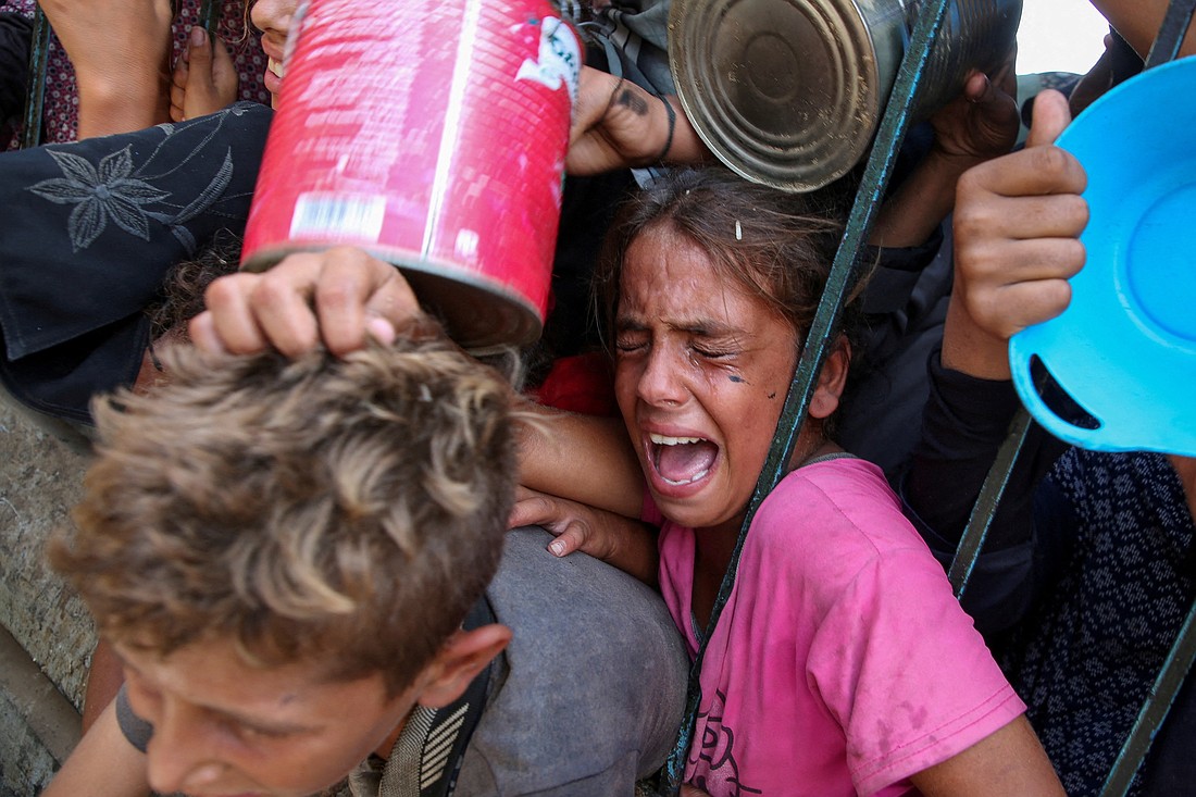 A Palestinian girl reacts as children wait to receive food cooked by a charity kitchen in Khan Younis, southern Gaza Strip, Sept. 13, 2024, amid the Israel-Hamas conflict. (OSV News photo/Hatem Khaled, Reuters)