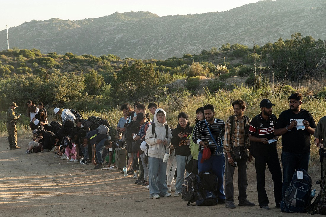 Asylum-seeking migrants stand in line be transported at a staging area near the border wall, after U.S. President Joe Biden announced a sweeping border security enforcement effort, in Jacumba Hot Springs, Calif., June 5, 2024. (OSV News photo/Go Nakamura, Reuters).